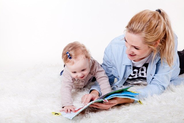žena s dítětem, prohlíží knihu
